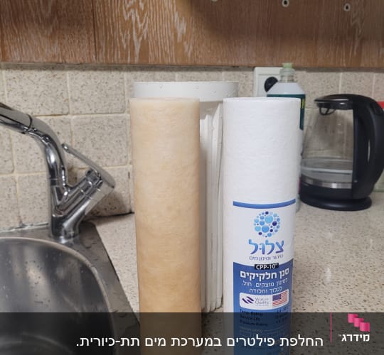 מסנן מים ומסנן חלופי ליד כיור מטבח